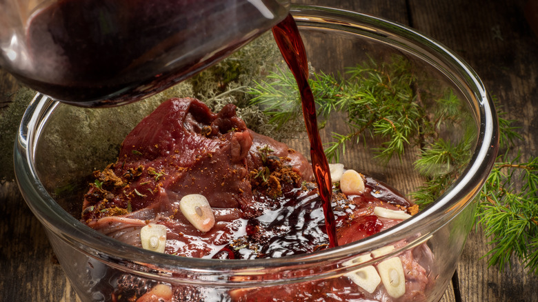 pouring liquid marinade over meat and spices