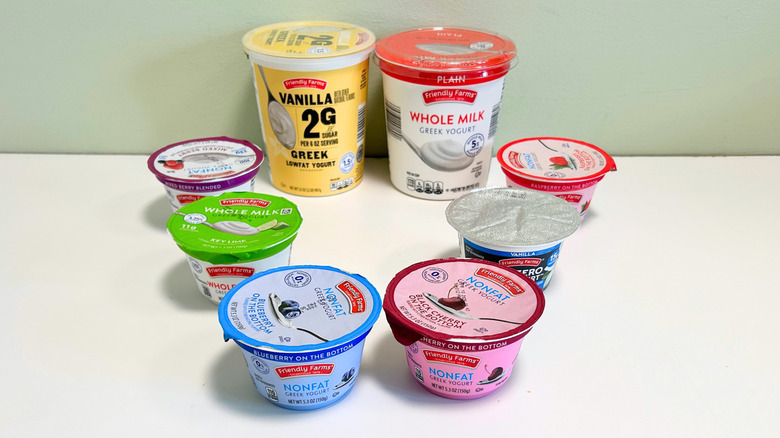 Eight containers of Aldi Friendly Farms Greek yogurts arranged together
