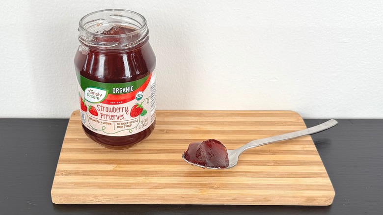 A jar of Simply Nature Organic Strawberry Preserves placed on a cutting board