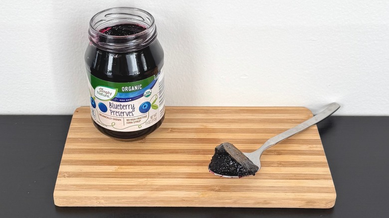 A jar of Simply Nature Organic Blueberry Preserves placed on a cutting board