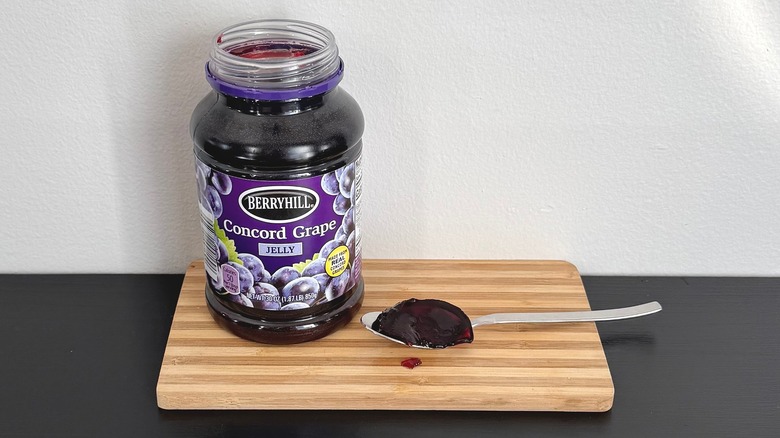 A jar of Berryhill Concord Grape Jelly placed on a cutting board