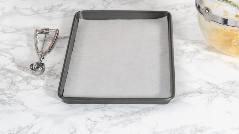 parchment lined baking sheet on marble
