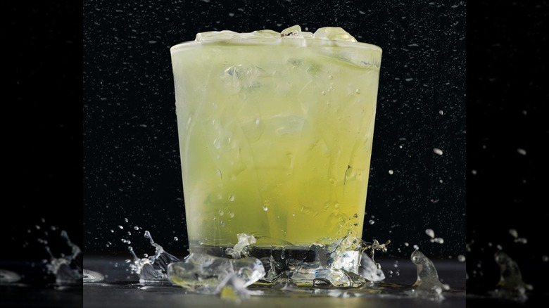 A margarita in a rocks glass against a black background