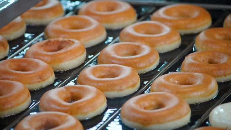 Krispy Kreme Original Glazed donuts rolling down an assembly line