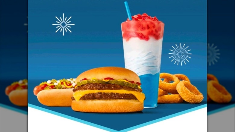 A loaded hot dog, double cheese burger, onion rings, and a red, white, and blue slushie float