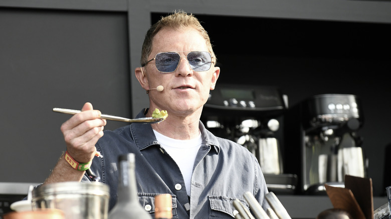 Bobby Flay holding a spoonful of food