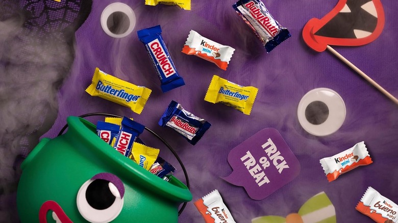 An assortment of chocolate candies spilling out of a monster Halloween bucket