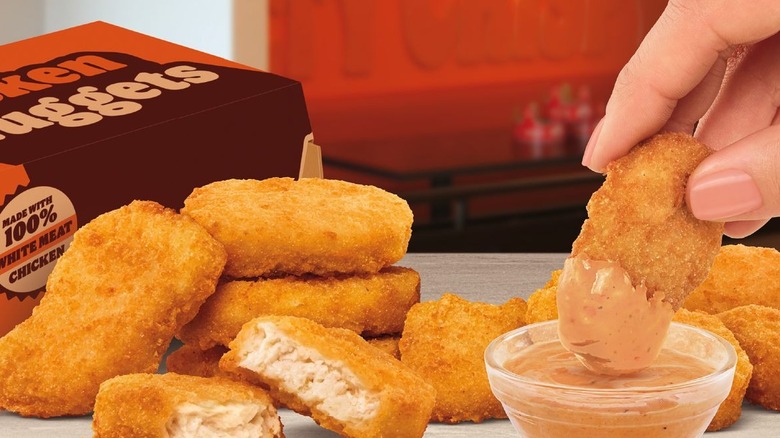 Burger King chicken nuggets being dipped into their new Special Savory Sauce