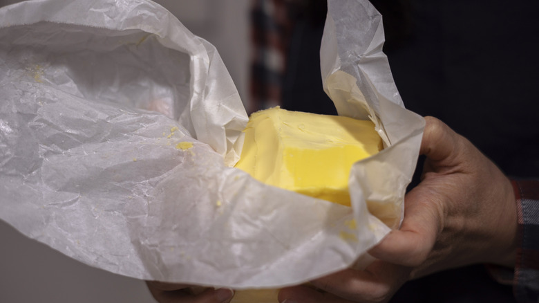 Man unwrapping a block of butter