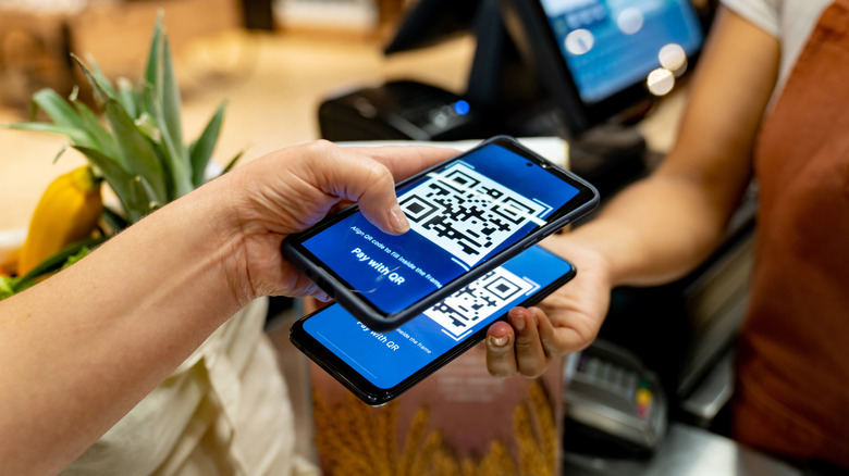 A hand scans a QR code on a phone