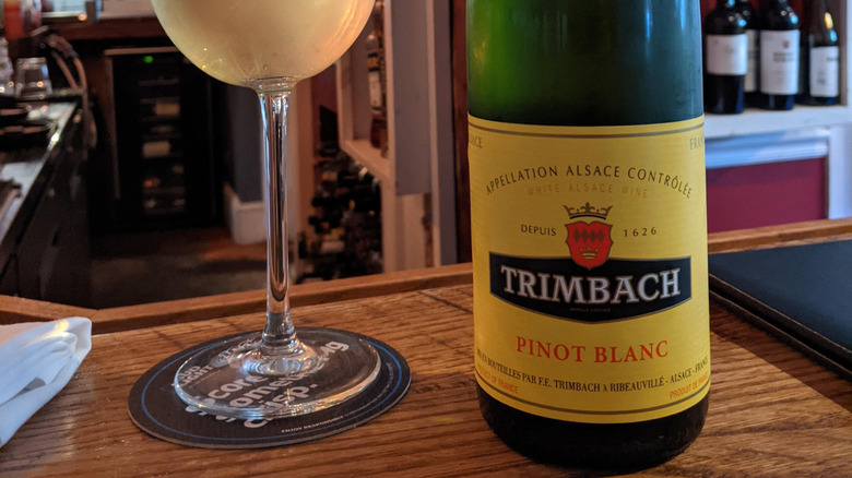Bottle of Trimbach pinot blanc next to glass on bar