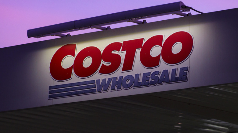 A Costco Wholesale sign is illuminated at dusk