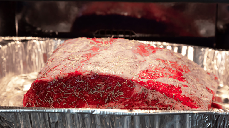 Uncooked prime rib in an aluminum tray