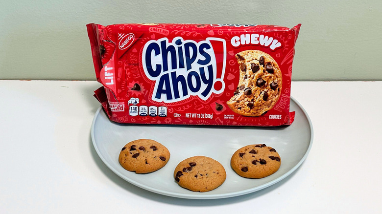 Three cookies on a plate with a bag of Chips Ahoy! Chewy