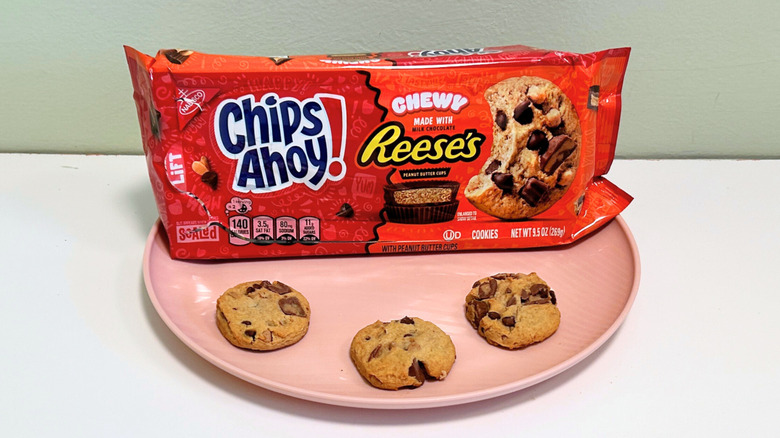 Three cookies on a plate with a bag of Chips Ahoy! Chewy Reese's