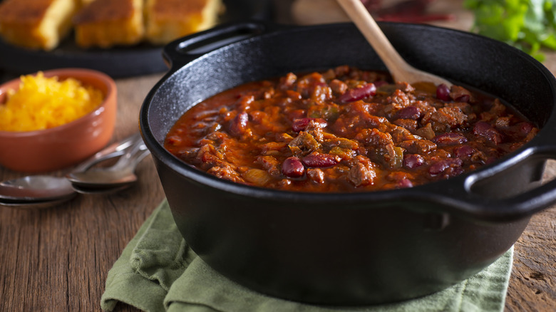 A cast iron pot of chili con carne posed on a tabletop