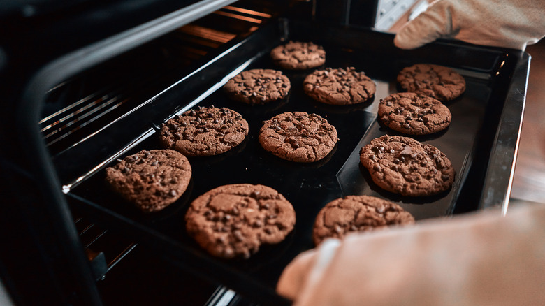 person taking cookies out of oven