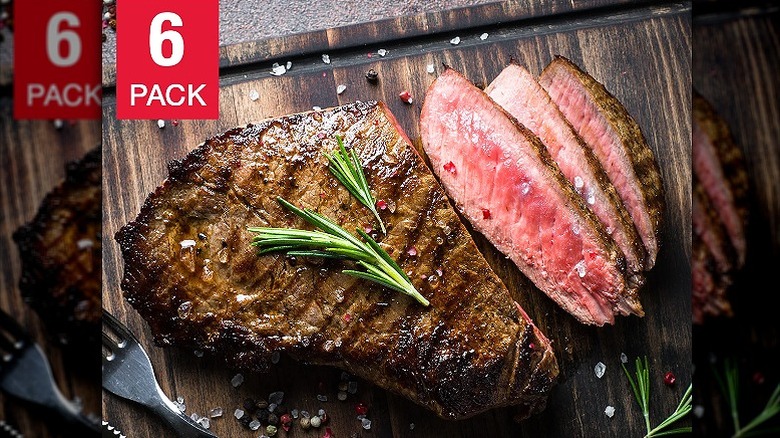 A bison steak cooked medium rare with garnish on top and 3 portions already sliced