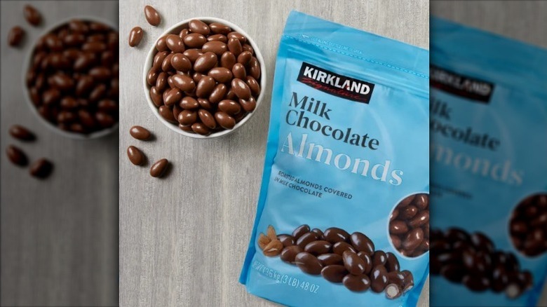 Kirkland milk chocolate almonds in bowl next to blue bag
