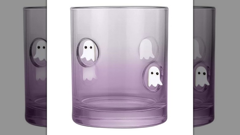 A purple glass tumbler with ghosts on a white background