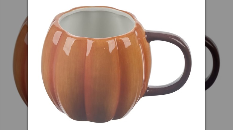 An orange pumpkin-shaped mug on a white background