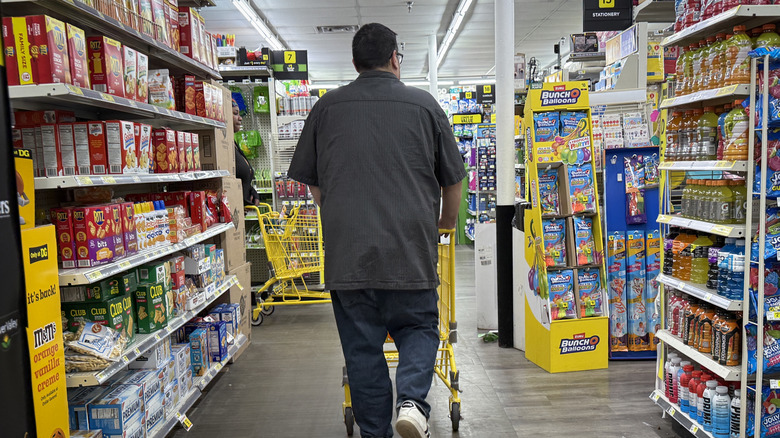 A person walking down an aisle at a Dollar General
