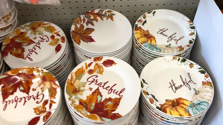fall-themed ceramic plates stacked on a shelf