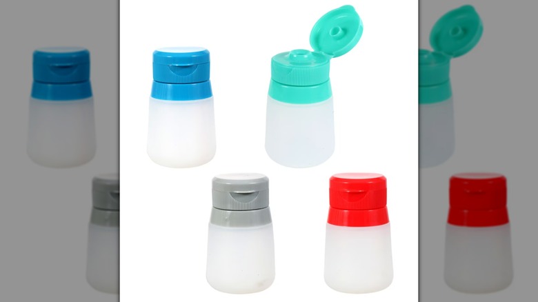 Four Cooking Concepts Silicone Travel Dressing Containers with blue, teal, gray, and red tops on a white background