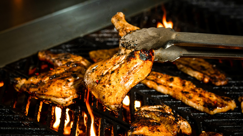 Cook turning chicken on grill
