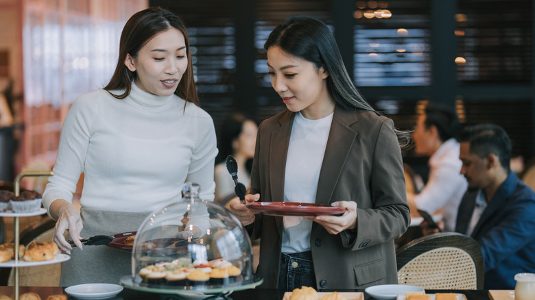 Women with pastries at buffet