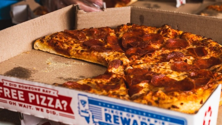 A close-up of a pepperoni pizza in a Domino's box
