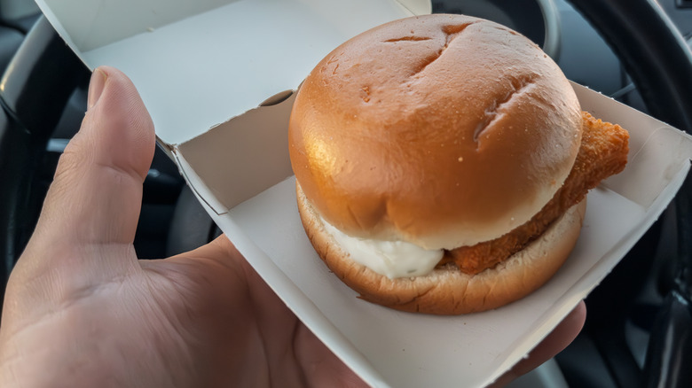 A hand holds a Filet-O-Fish in a box