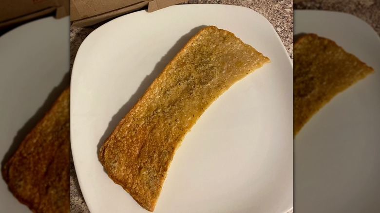 A flat, unrisen breadstick on a white plate