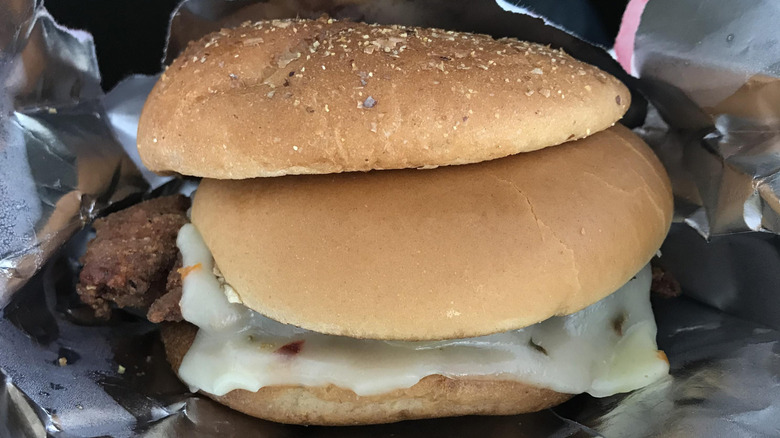 A fast food chicken sandwich with both a white bun and a wheat bun