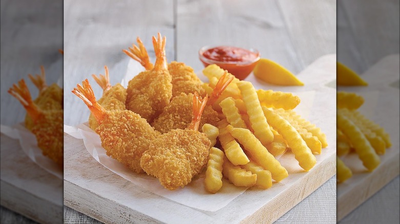 Culver's Butterfly Jumbo Shrimp on cutting board with fries and dipping sauce.