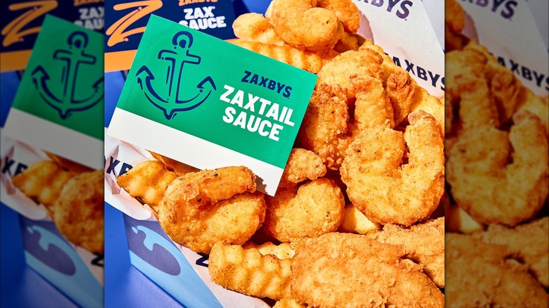 Close-up of Zaxby's Southern Fried Shrimp with fries and Zaxtail Sauce in a box.