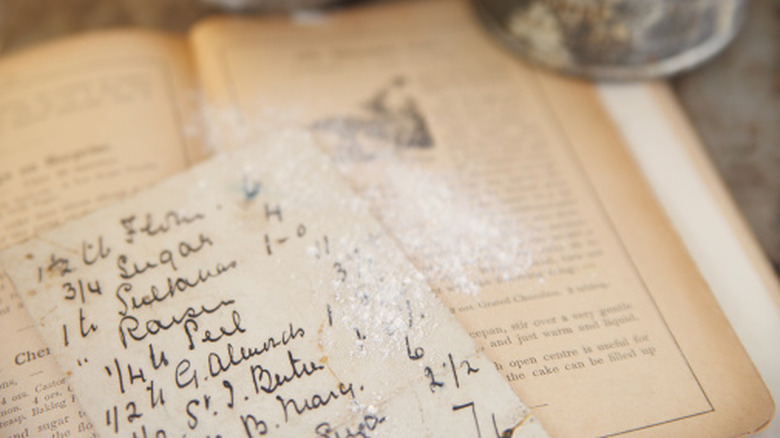Close-up image of vintage cookbook with a hand-written recipe card.