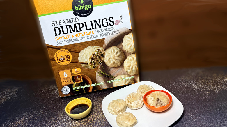 Plate of chicken dumplings with bowl of dipping sauce and package