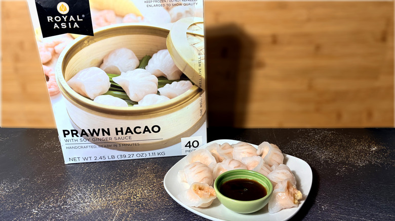 Plate of prawn dumplings with bowl of dipping sauce and package