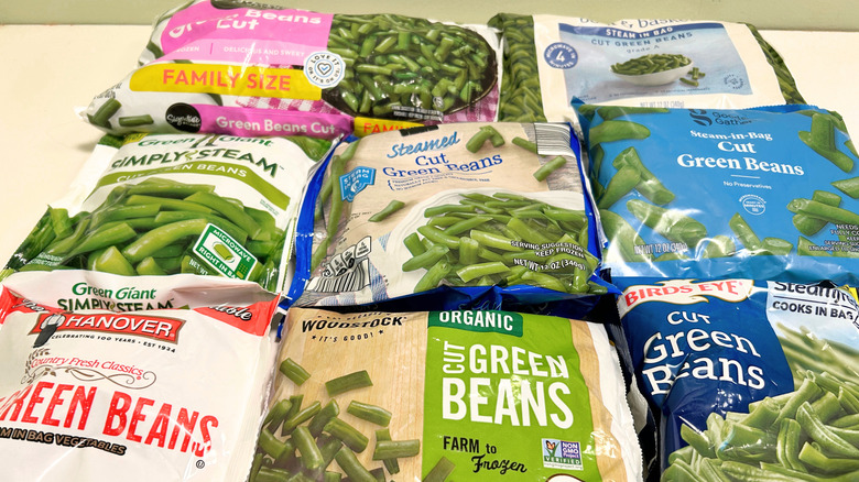 Eight frozen green bean brands arranged on a white surface