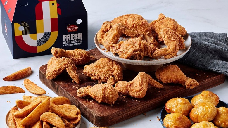 krispy krunchy chicken styled with sides and packaging on white background