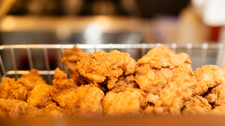 close-up of fried chicken in a frying basket against blurred background
