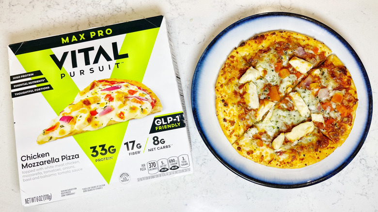 A Vital Pursuit Chicken Mozzarella pizza on a blue plate next to its box