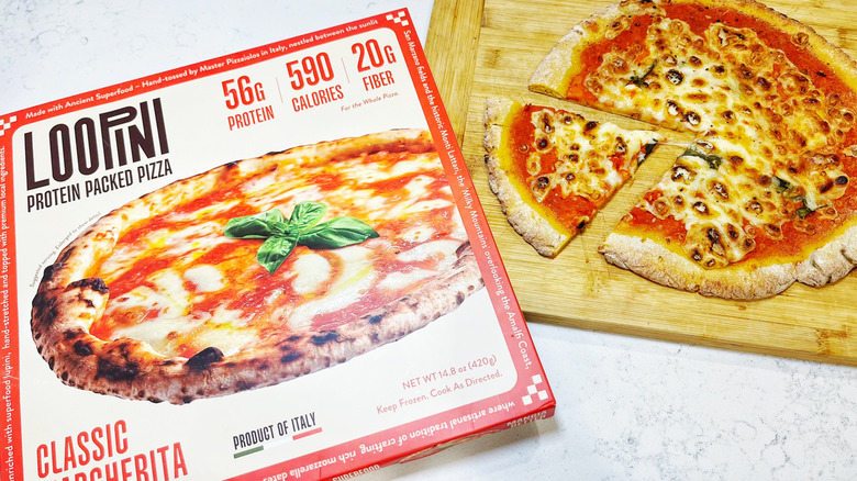 A Loopini Classic Margherita baked on a cutting board with a slice pulled out