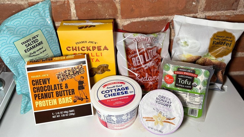 A lineup of trader joes products on a white table against a brick background