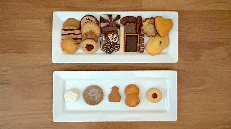 Two rectangular white plates of assorted cookies