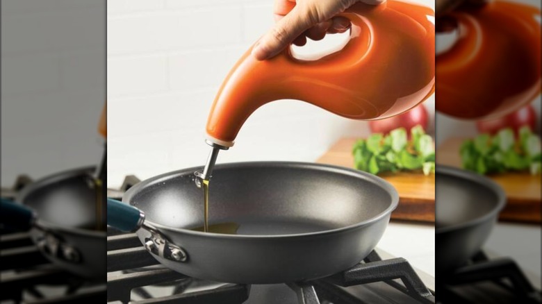 oil being poured from oil dispenser into pan