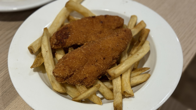 Chicken tenders and fries on a white plate