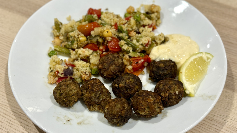 Falafel balls and vegetable couscous on a white plate