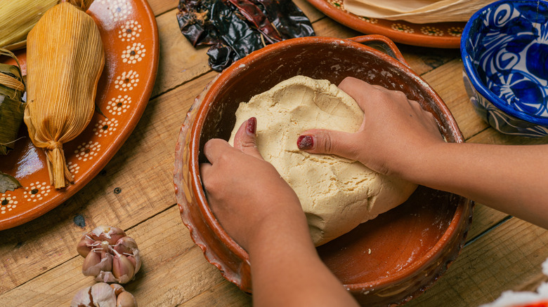 Woman kneading fresh masa dough for tamales